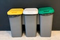 Colored plastic trash bins near the wall