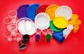 Colored plastic utensils on red background Royalty Free Stock Photo