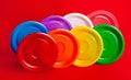 Colored plastic utensils on red background