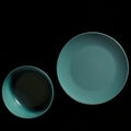 Colored plates of different shapes stand on a black background