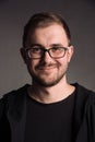 Portrait of smiling man in black t-shirt on gray studio background posing to the camera Royalty Free Stock Photo