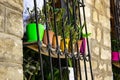 Colored pots with flowers on the window cage