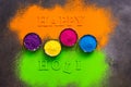 Colored powder in bowls for holi festival. Happy holi lettering. Beautiful bright background from colorful powder. Top view