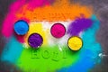 Colored powder in bowls for holi festival. Happy holi lettering. Beautiful bright background from colorful powder. Top view