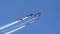 Colored propeller airplanes participate in jet races and smoke during air show.