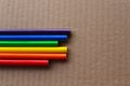 colored rainbow columns of pencils on a brown corrugated box surface background Royalty Free Stock Photo