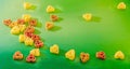 Colored (red, yellow an orange) heart shape pasta, colored degradee bokeh background, close up Royalty Free Stock Photo