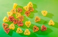 Colored (red, yellow an orange) heart shape pasta, colored degradee bokeh background, close up Royalty Free Stock Photo