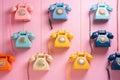 Colored retro telephones hanging on pink background.