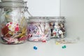 Colored ribbons and colorful buttons in glass jars for creating artistic hobbies