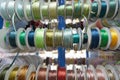 Colored ribbons for needlework in coils on the shelf in store. Close-up Royalty Free Stock Photo