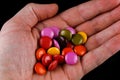 Colored round chocolates or chewing gum in hand Royalty Free Stock Photo
