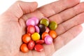 Colored round chocolates or chewing gum in hand Royalty Free Stock Photo