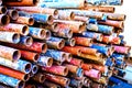 A heap of colored rusty pipes on the street