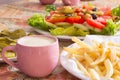 Colored salad and frensh fries with Pickled Cucumber and cup