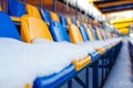 Colored seats snow covered in winter snowy stadium. Snow covered tribune