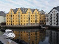 Colored secessionist buildings of european Alesund town and yacht reflected in water at Romsdal region in Norway Royalty Free Stock Photo