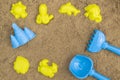 Colored shovel and rake and molds in sandbox. Outdoor children`s sand toys. Summer concept Royalty Free Stock Photo