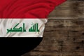 Colored silk national flag of state of Iraq lies on old wood, concept of tourism, economy, politics