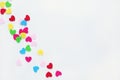 Colored small hearts on a white background.