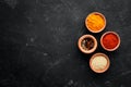 Colored spices on a black stone background. Free space for your text. Royalty Free Stock Photo