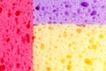 Colored sponges for washing dishes and other domestic needs. View from above. The texture of red, purple and orange sponges are sp