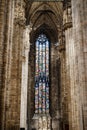 Colored stained glass window against the columns and arched ceiling in the Duomo. Italy, Milan Royalty Free Stock Photo