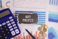 A colored sticker with the text NET PROFIT lies on the calculator Royalty Free Stock Photo