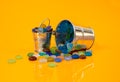 colored stones in glass in jar in bucket on orange background Royalty Free Stock Photo