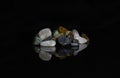 Colored Stones Reflected on Black Surface Royalty Free Stock Photo