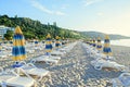 Colored stripped sun umbrellas, beach sand and beds