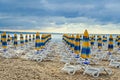 Colored stripped sun umbrellas, golden beach sand and sunbeds