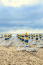 Colored stripped sun umbrellas, golden beach sand and sunbeds, s