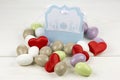 Colored sugared almonds red heart shaped confetti and papery box