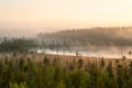 Colored sunrise in forest lake with fog, evergreen trees on bog. Northern Karelia, Russia Royalty Free Stock Photo