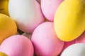 Colored sweet little eggs. Multi-colored Easter eggs on a plate. Sweet Easter eggs shot close up. Festive chocolate eggs in pink,