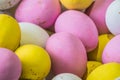 Colored sweet little eggs. Multi-colored Easter eggs on a plate. Sweet Easter eggs shot close up. Festive chocolate eggs in pink,