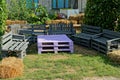 Colored table and chairs of wooden pallets stand on the green grass