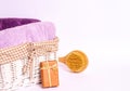 Colored terry towels in a basket, a wooden massage brush, soap on a white background Royalty Free Stock Photo