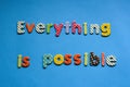 colored text everything is possible on blue paper background. Royalty Free Stock Photo