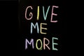 Colored text `give me more`written  on chalkboard Royalty Free Stock Photo