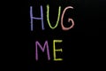 Colored text hug me drawned on chalkboard