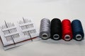 Colored threads and needles. Everything you need for sewing. Several spools of thread. Sharp needles.Red, black, gray and blue thr Royalty Free Stock Photo