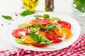 Colored tomato salad with onion and basil pesto.