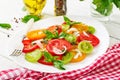 Colored tomato salad with onion and basil pesto. Royalty Free Stock Photo