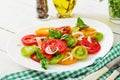 Colored tomato salad with onion and basil pesto.