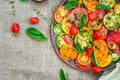 Colored tomato salad with onion and basil. Vegan food. Royalty Free Stock Photo