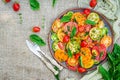 Colored tomato salad with onion and basil. Vegan food.