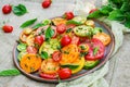 Colored tomato salad with onion and basil. Vegan food.