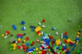 Colored toy bricks with place on green ground very messy Royalty Free Stock Photo